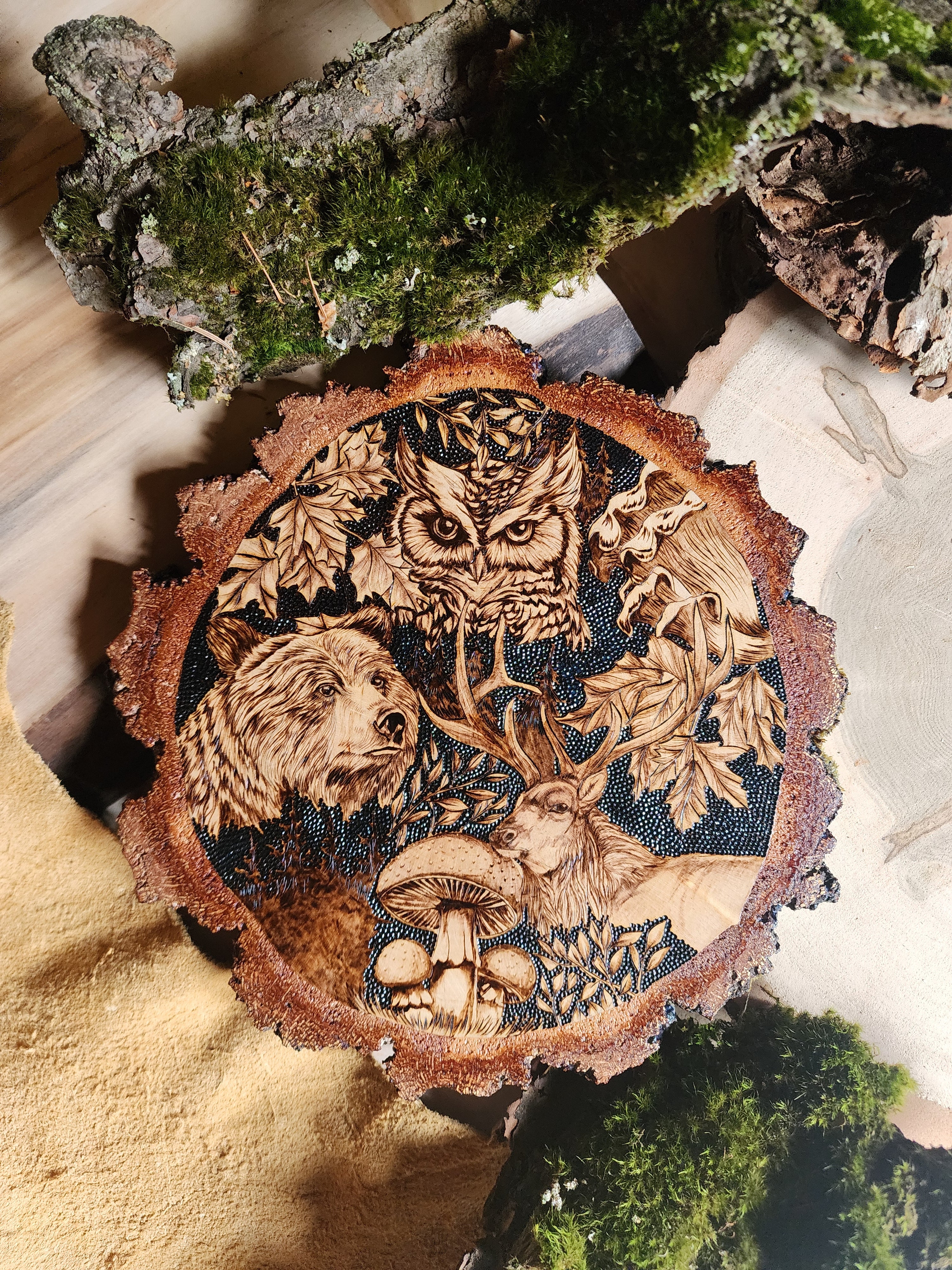 wildlife depicted in pyrographic art, an owl, bear and elk with burn art mushrooms and leaves