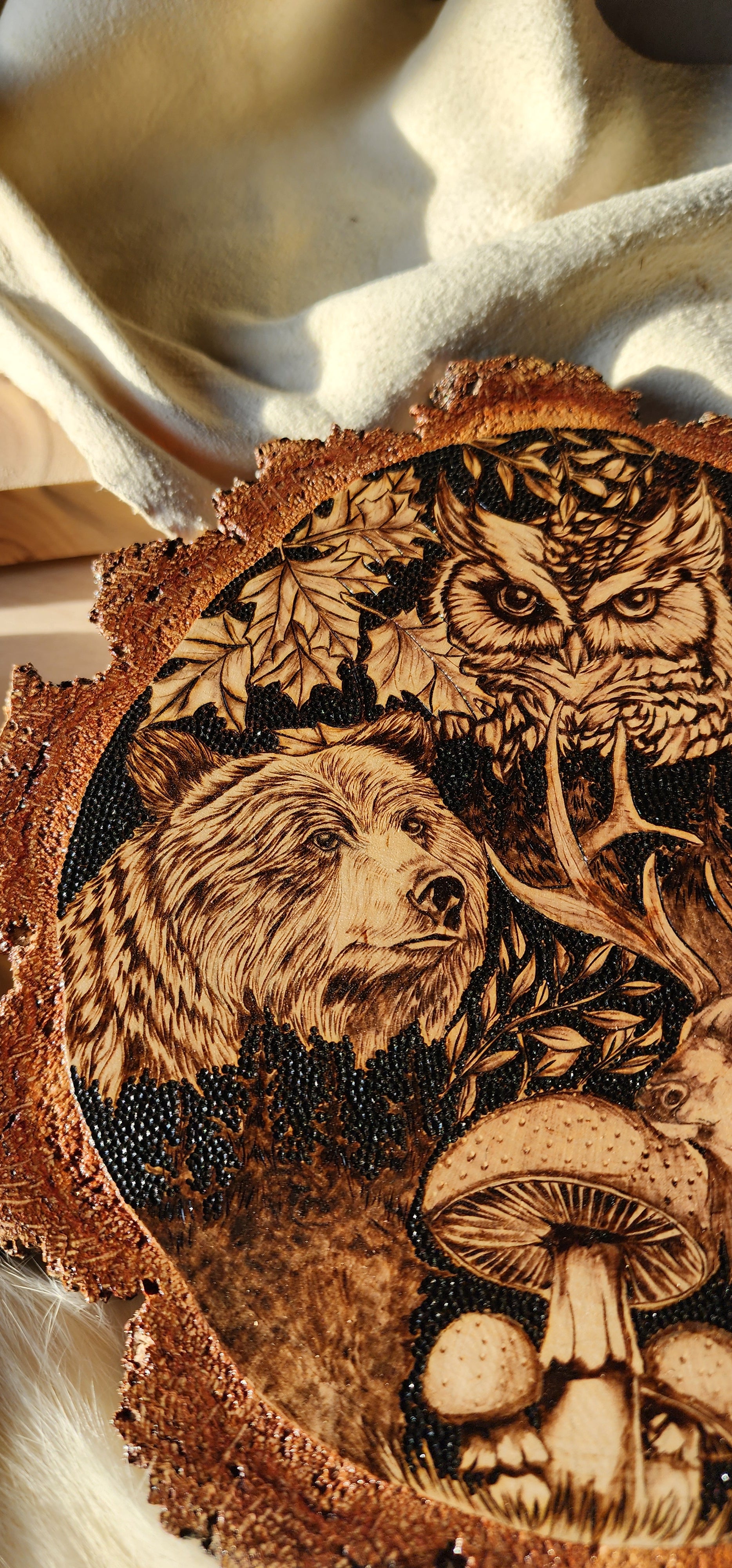 wildlife depicted in pyrographic art, an owl and bear with burn art mushrooms and leaves