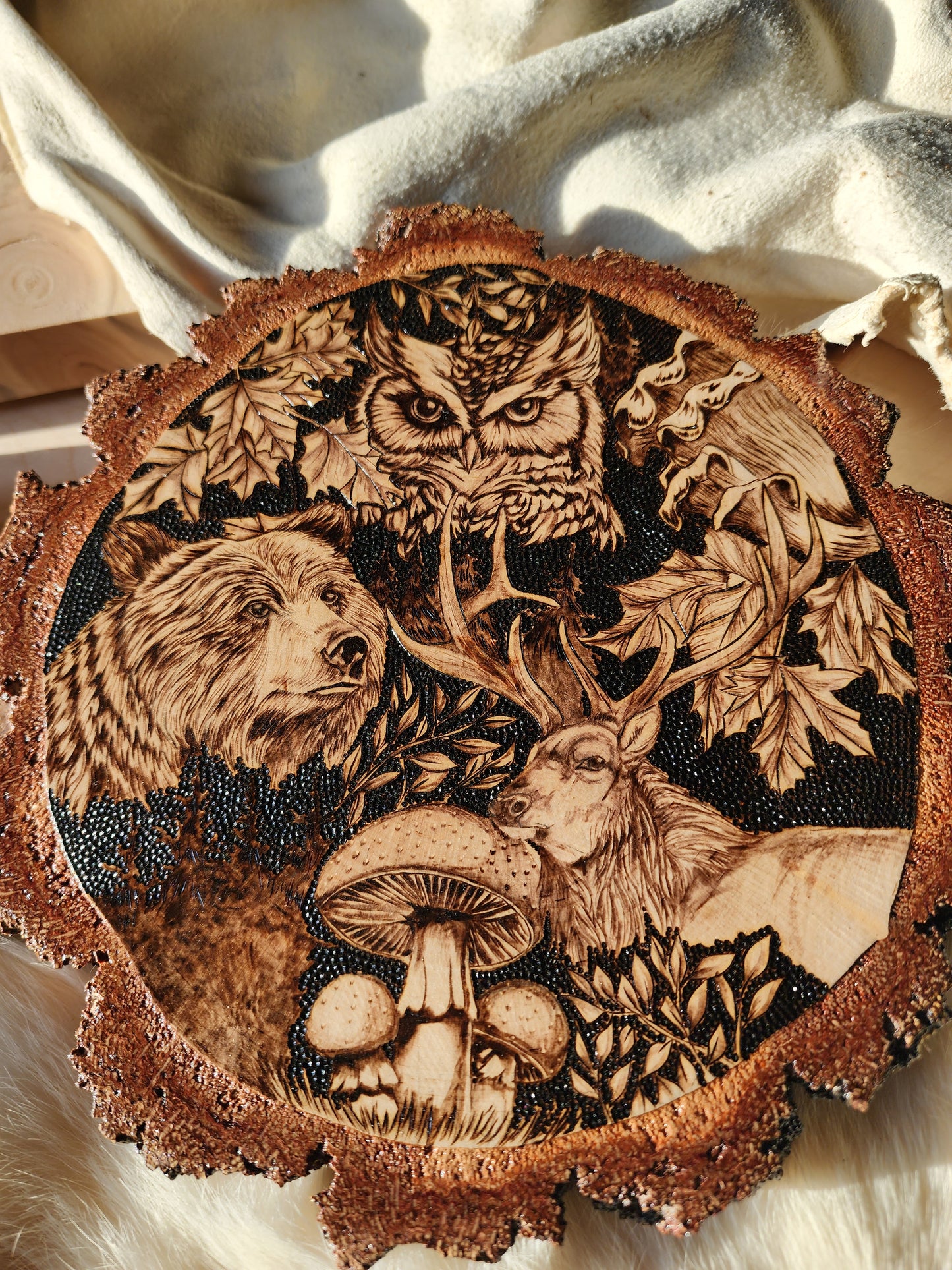 wildlife depicted in pyrographic art, an owl, bear and elk with burn art mushrooms and leaves