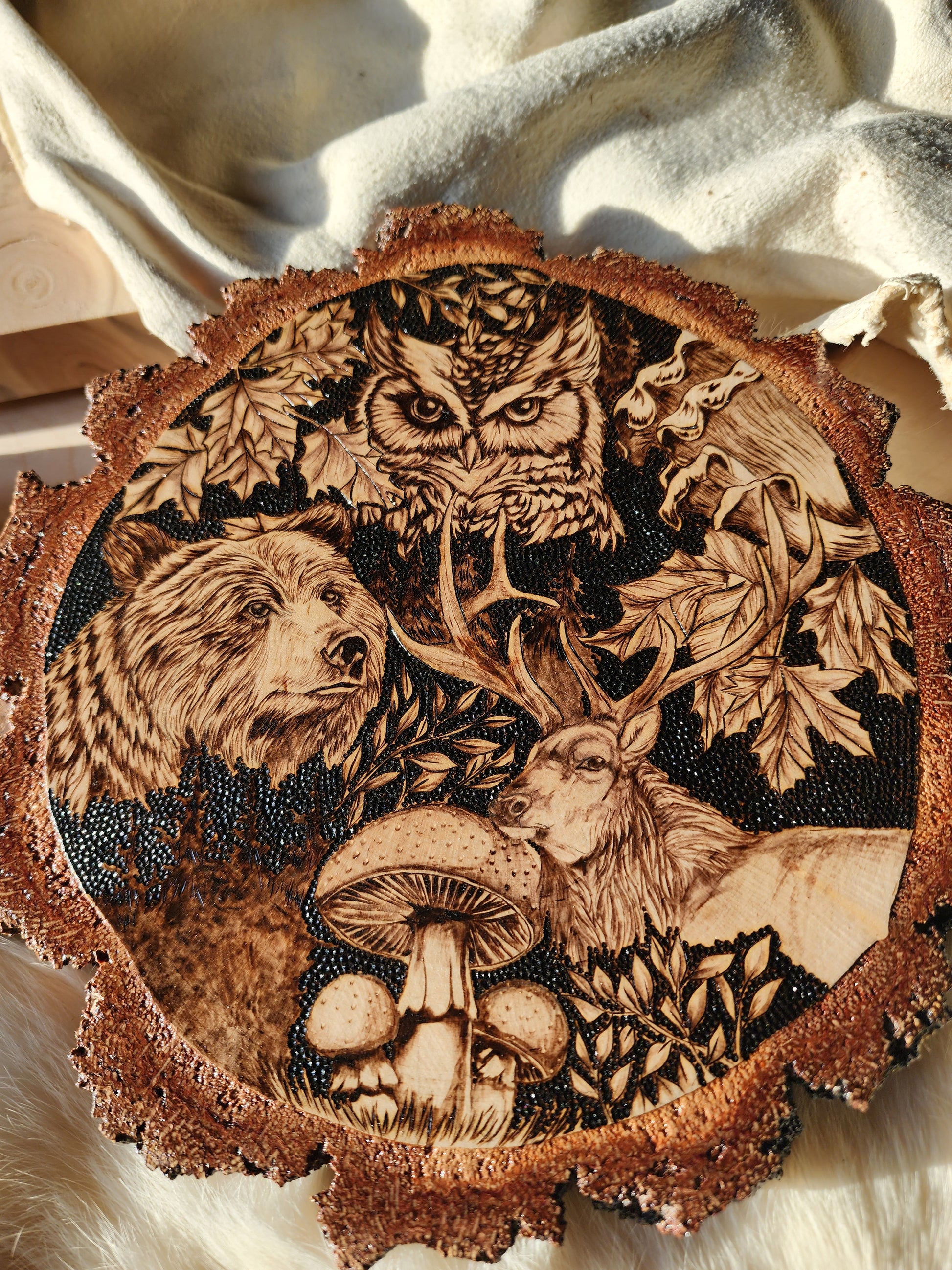 wildlife depicted in pyrographic art, an owl, bear and elk with burn art mushrooms and leaves